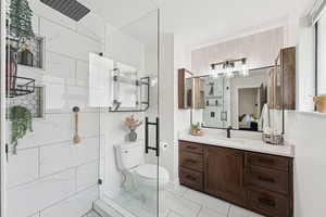 Ensuite bathroom featuring vanity, a stall shower, and light marble finish floors