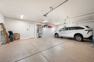 Garage with baseboards and strapped water heater