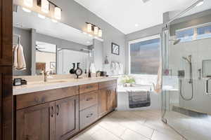 Ensuite bathroom with double vanity, a bath, and a shower stall