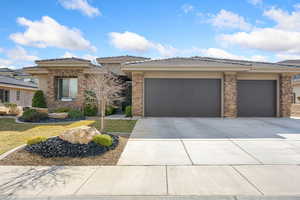 Prairie-style house with an attached garage, concrete driveway, a tiled roof, and a front lawn