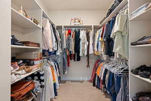 Walk in closet with light carpet
