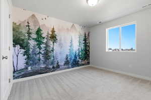 Spare room featuring light carpet and baseboards