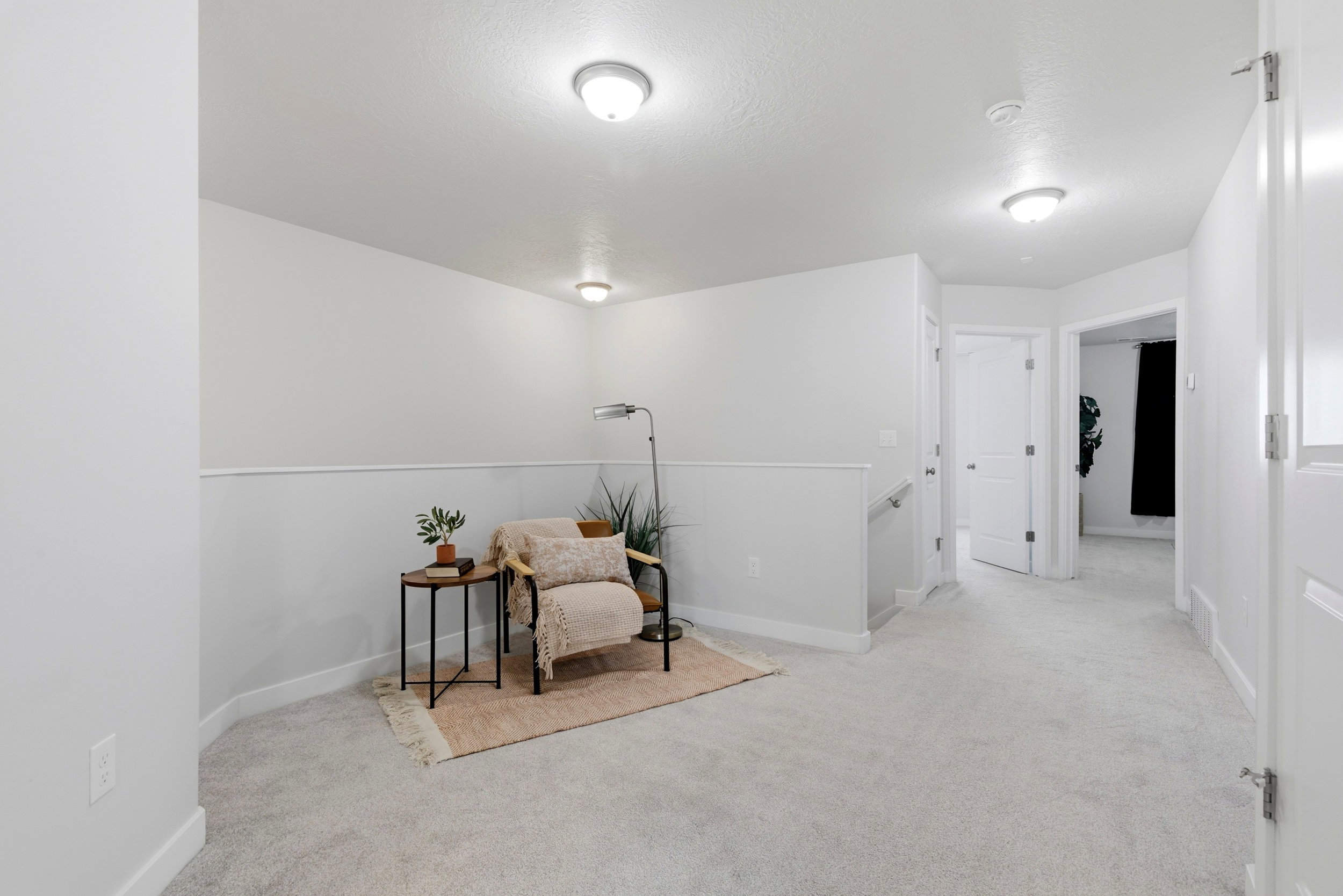 Living area featuring light carpet and an upstairs landing