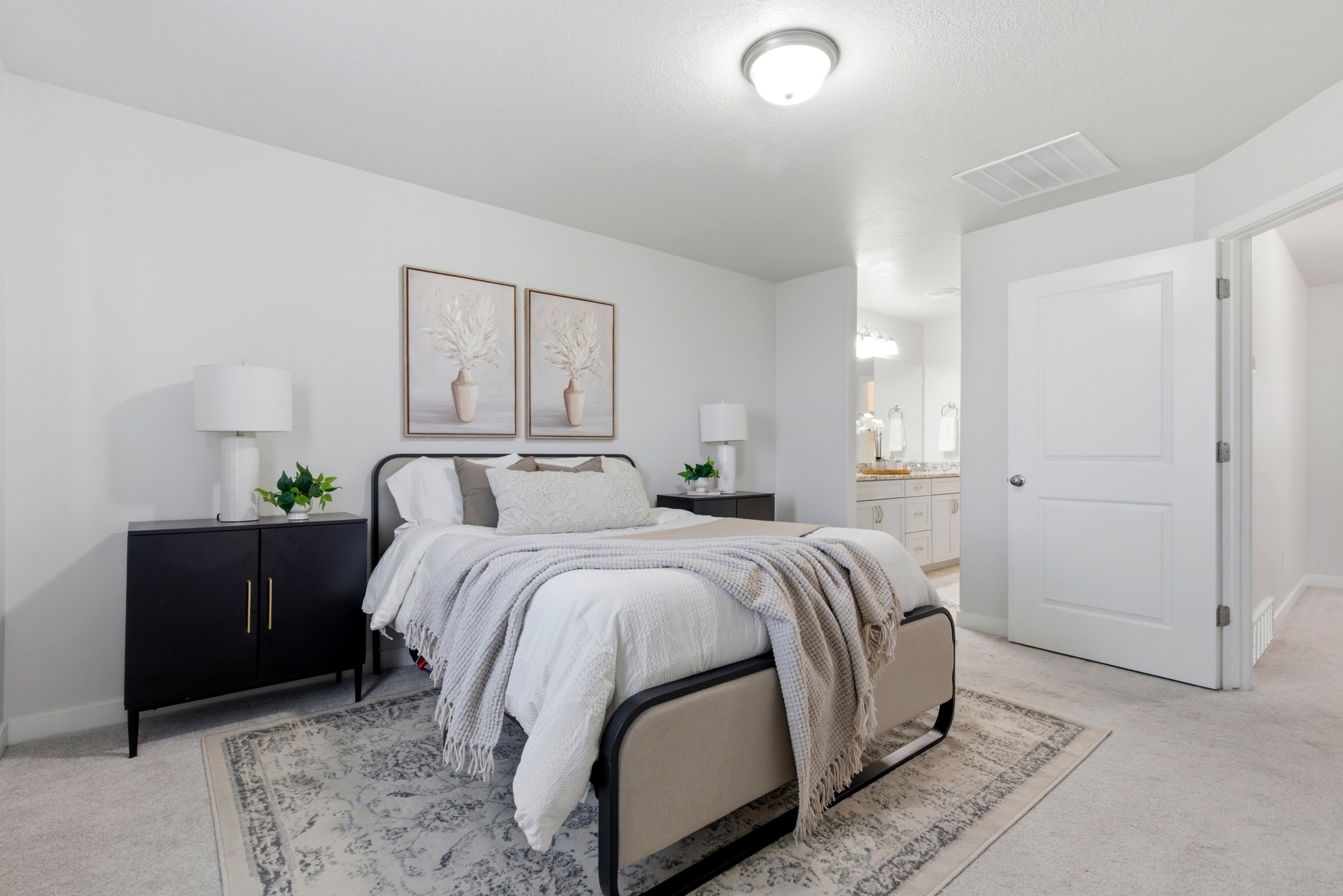 Bedroom with light colored carpet and connected bathroom