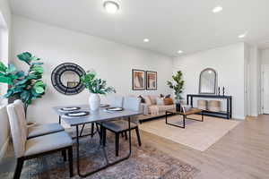 Dining room with light wood finished floors and recessed lighting
