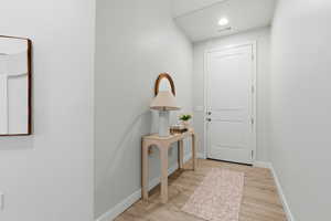 Doorway featuring wood finished floors and recessed lighting