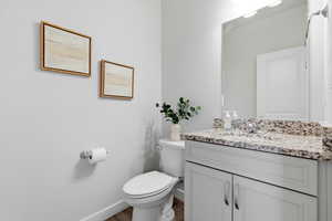 Half bath featuring vanity and dark wood-style floors