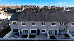 Rear view of property with stucco siding, a residential view, a fenced backyard, and a patio