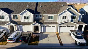 View of front of property featuring board and batten siding, a residential view, roof with shingles, and an attached garage