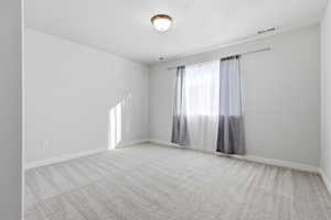 Unfurnished room with light carpet and baseboards