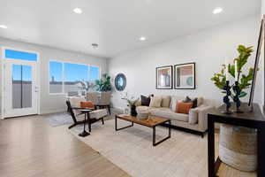 Living area with light wood-style flooring and recessed lighting