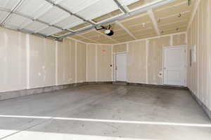 Garage featuring a garage door opener and electric panel