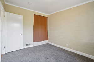 Unfurnished bedroom with carpet floors, ornamental molding, and a closet