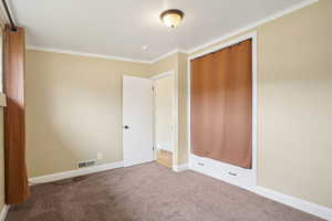 Unfurnished bedroom featuring carpet and crown molding