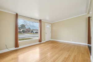 Entrance foyer featuring light wood-type flooring and crown molding