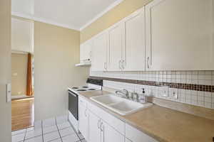 Kitchen featuring white cabinetry, light countertops, and tile floors - north unit