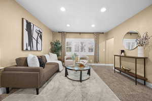 Carpeted living area with baseboards and recessed lighting