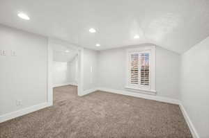 Additional living space featuring carpet, vaulted ceiling, and recessed lighting