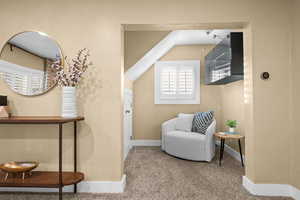 Sitting room featuring carpet and vaulted ceiling