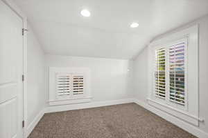 Bonus room with vaulted ceiling, dark carpet, and recessed lighting