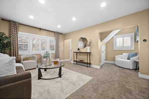Carpeted living room with baseboards and recessed lighting