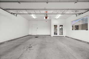 Garage featuring french doors and baseboards