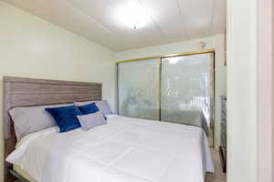 Carpeted bedroom with a closet and vaulted ceiling