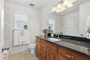 Primary bath with vanity and light tile patterned floors