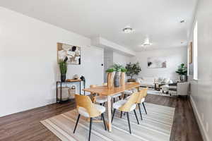Dining space featuring baseboards and dark wood-style flooring