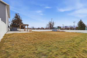 Fenced backyard with a storage unit, a patio area, and a pergola