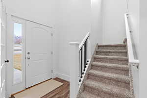 Foyer entrance with stairway and wood finished floors