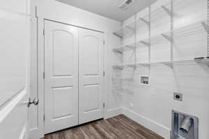 Laundry room with washer hookup, dark wood-type flooring, and electric dryer hookup