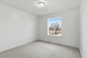 Spare room featuring baseboards and light carpet