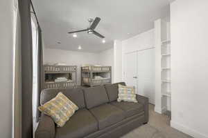 Living area featuring a ceiling fan and carpet floors