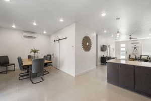 Dining room featuring a barn door, a ceiling fan, and recessed lighting