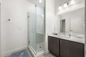 Bathroom with vanity, a stall shower, and recessed lighting