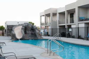 Community pool with a patio and a water slide