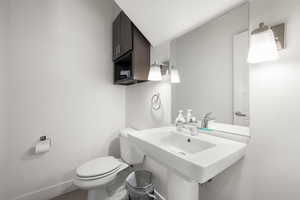 Half bathroom featuring toilet and baseboards