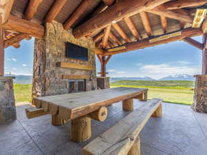 View of patio / terrace featuring an outdoor stone fireplace