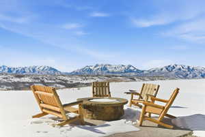 Snow covered patio featuring a fire pit and a mountain view
