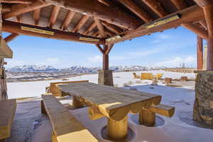 Snow covered patio featuring a mountain view, a patio, and outdoor dining space