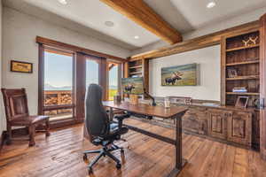 Home office with light wood-style flooring, beam ceiling, recessed lighting, and built in features