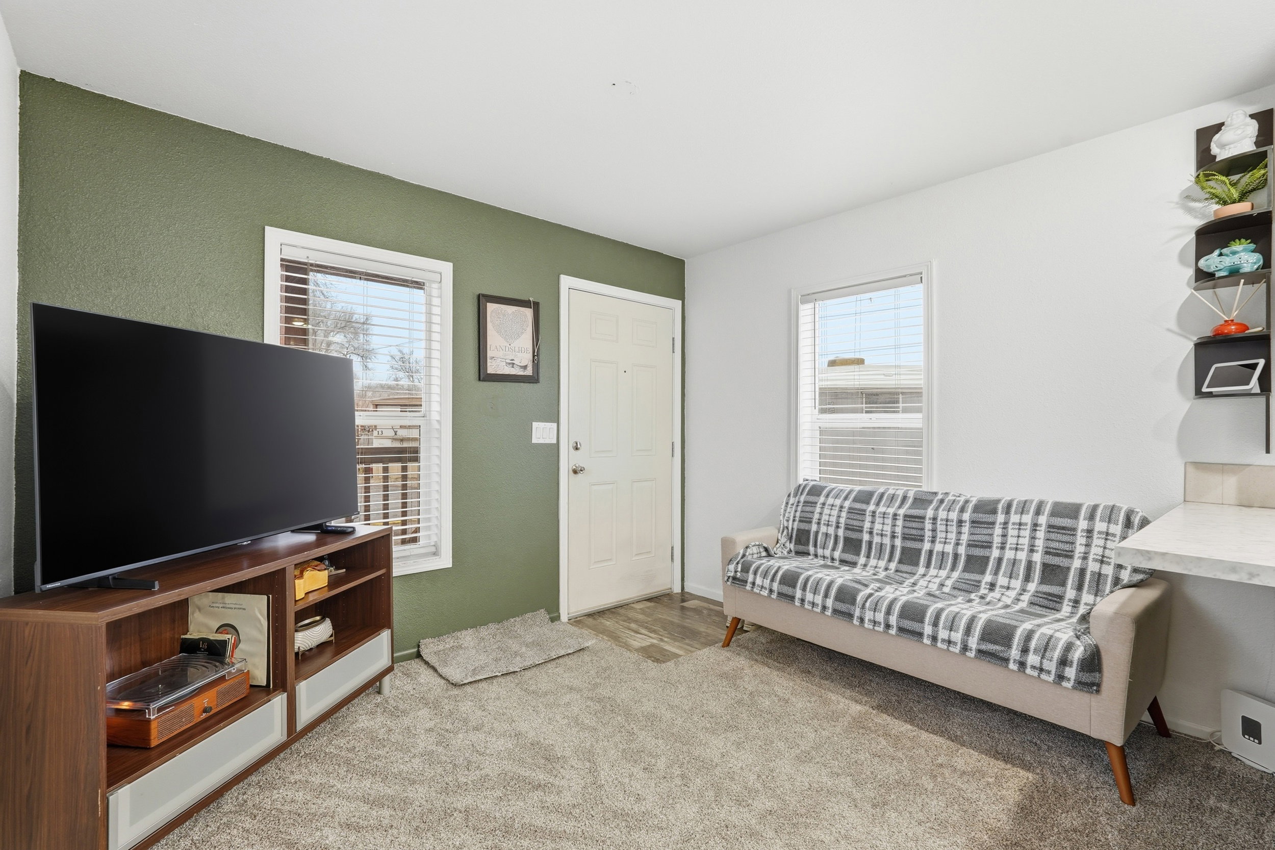 Living room featuring light colored carpet and healthy amount of natural light