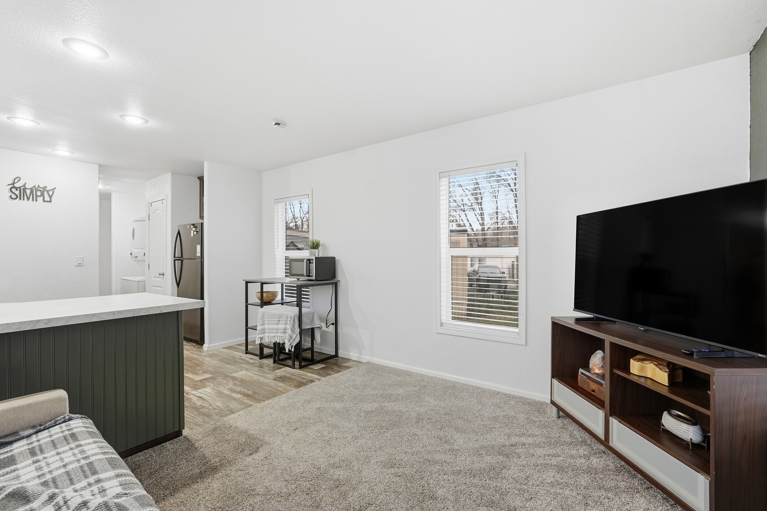 Living area featuring light colored carpet and recessed lighting