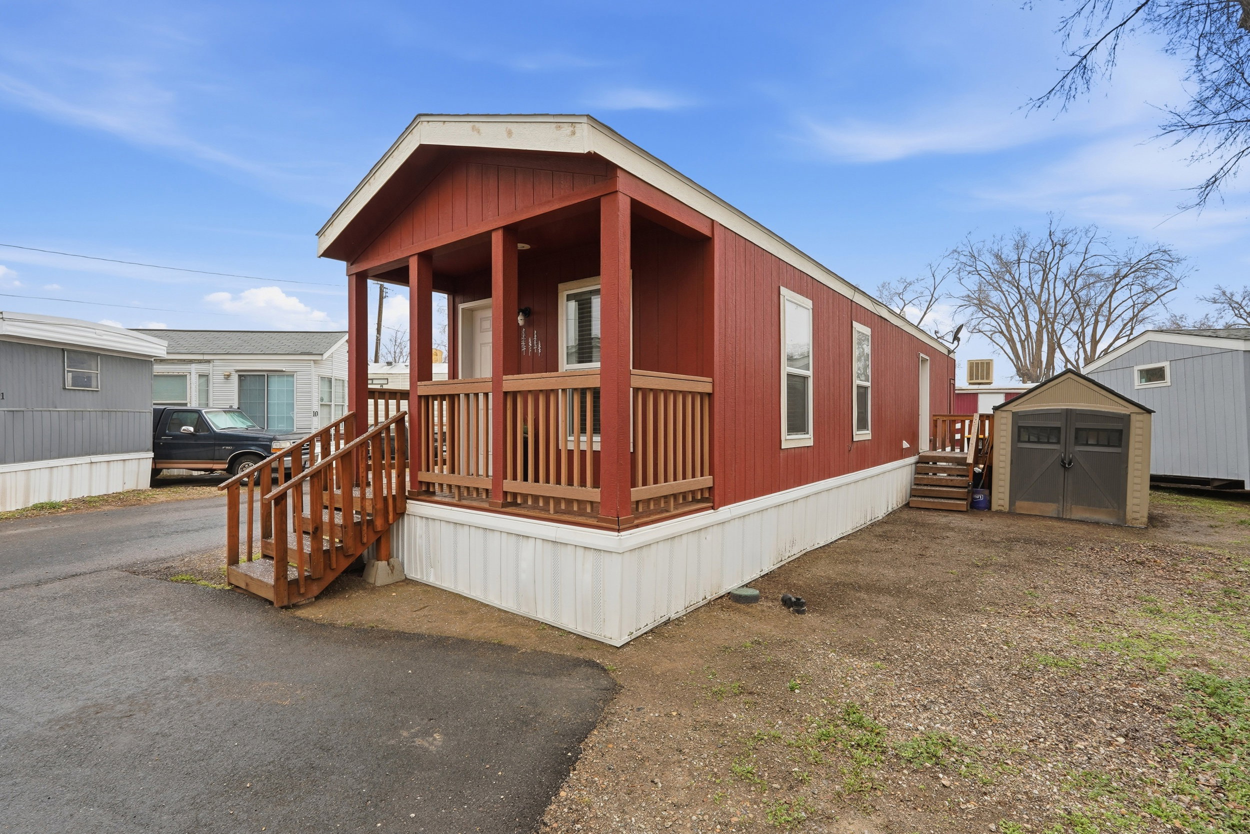 View of front of house featuring a storage unit and a porch