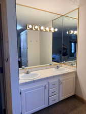 Bathroom featuring double vanity and a textured wall