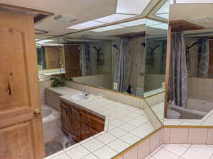 Full bathroom with vanity and light tile patterned floors