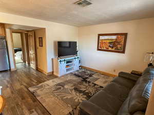Living room with dark wood-style floors and a textured ceiling