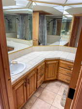 Bathroom with double vanity and light tile patterned floors