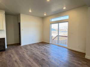 Empty room with recessed lighting, a textured ceiling, and dark wood-style floors
